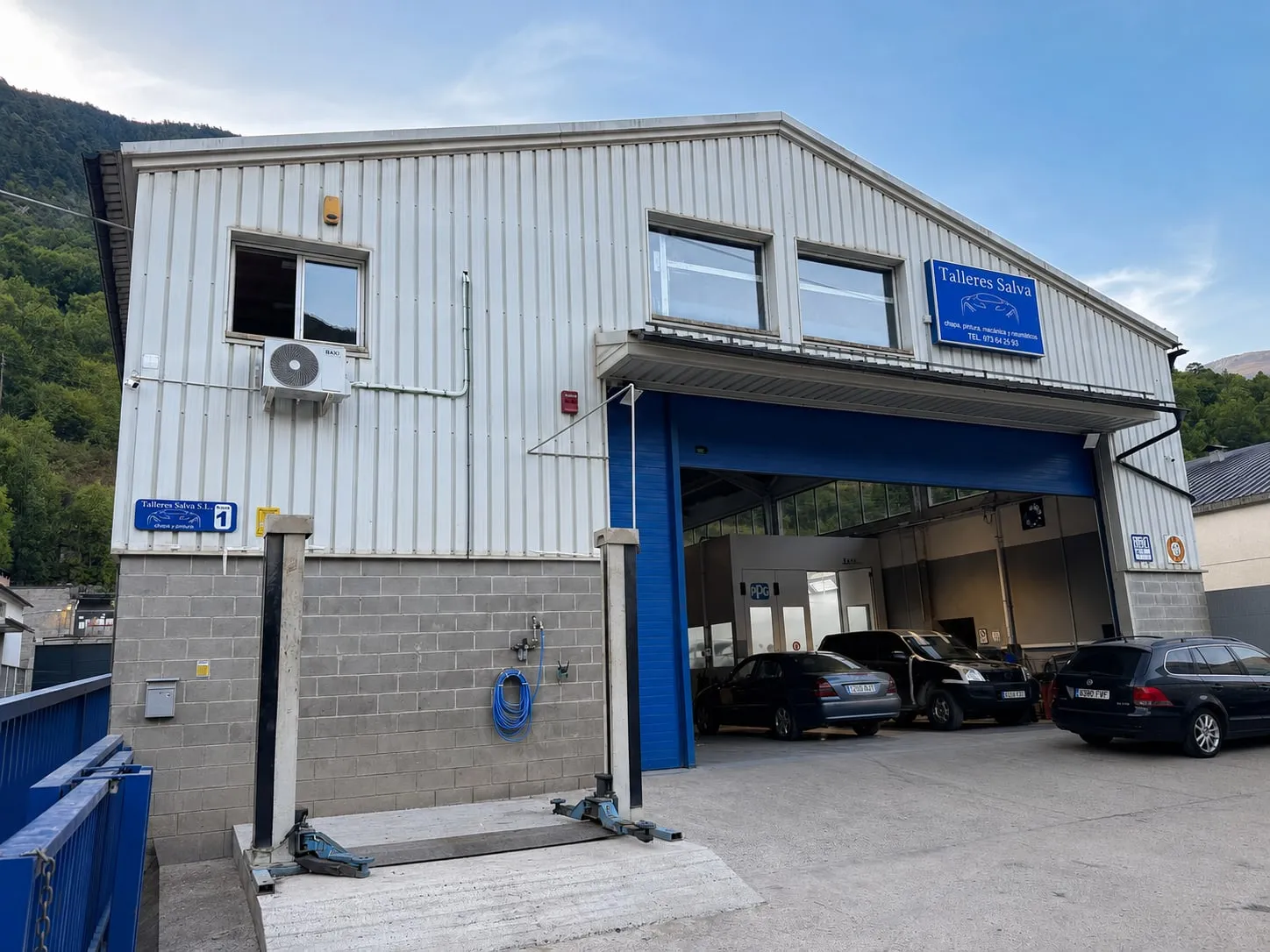 Fachada de Talleres Salva en el Polígono Industrial de Mijaran, con la puerta azul abierta